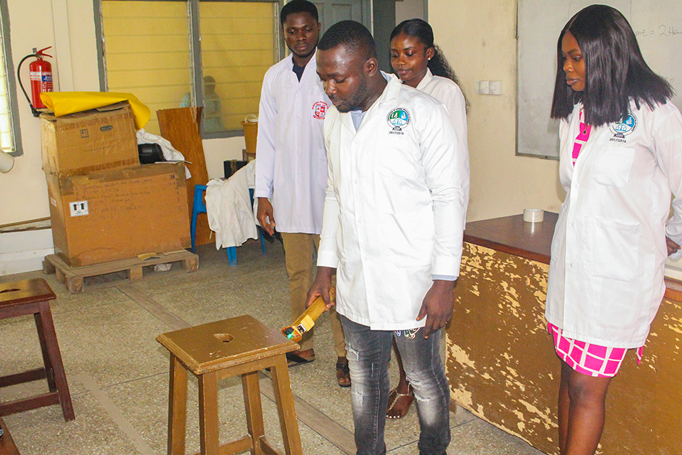 A student displaying how the visually-impaired stick uses infrared sensors to detect objects that are close by