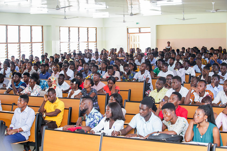 Students attentively listening  to the lecture and jotting down key points