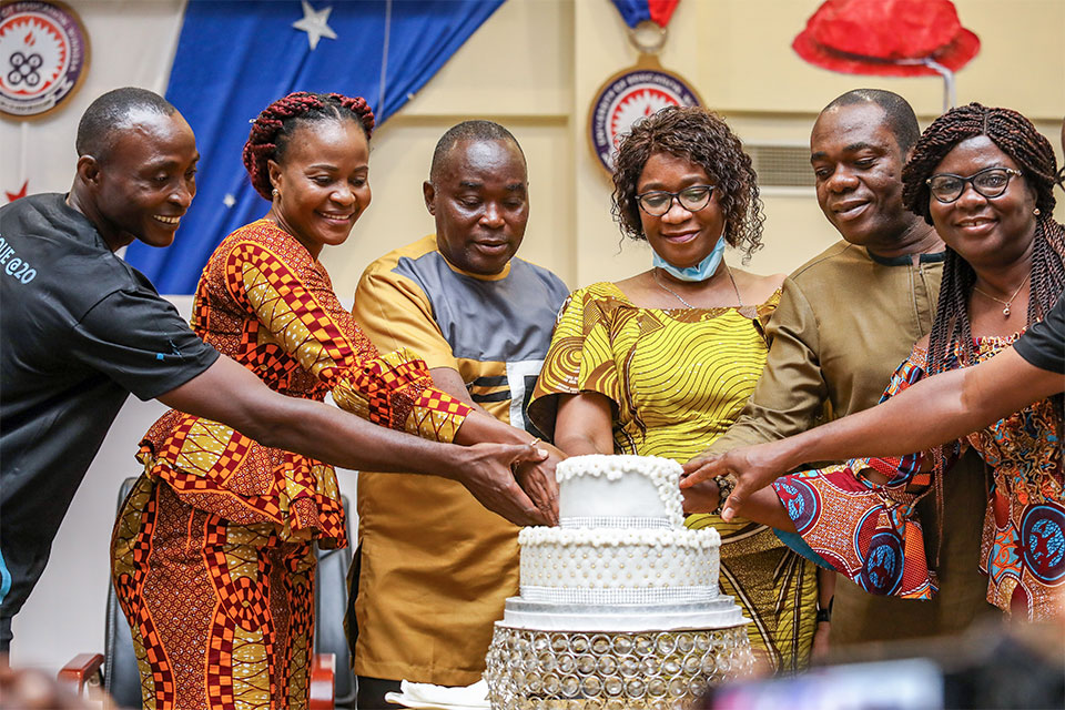 Dignitaries and invited guests cutting the anniversary cake