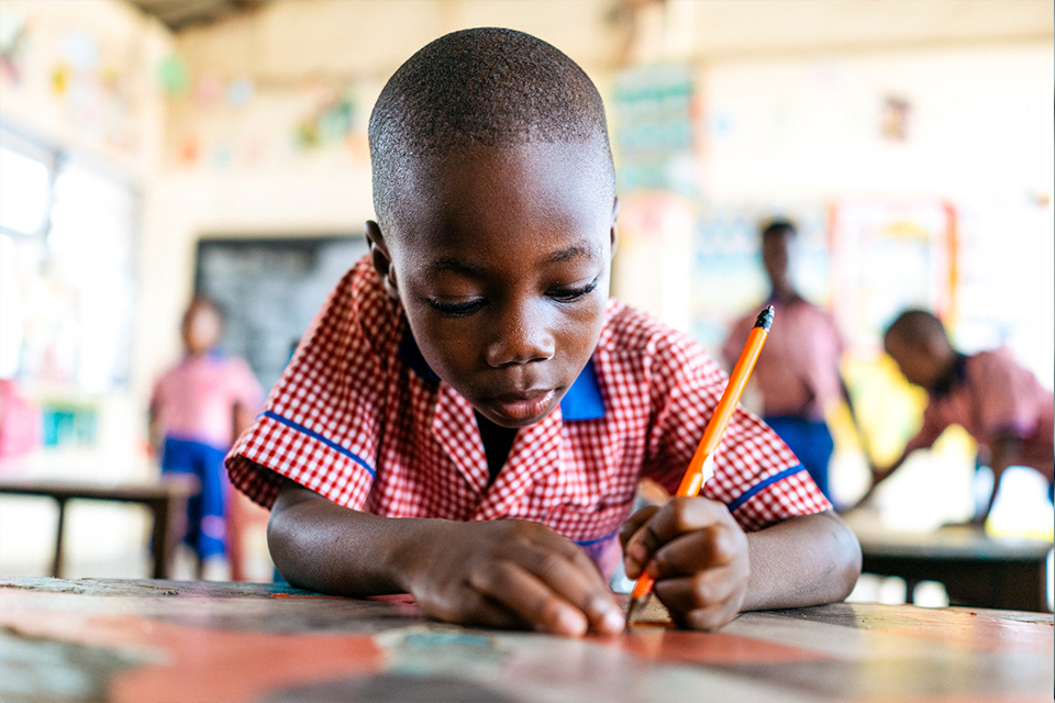 A pupil writing with pencil