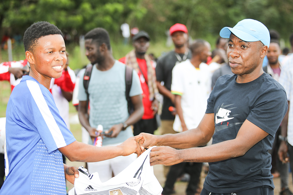 Dr. Ernest Yeboah Acheampong (right) presenting a jersey to the woman of the match