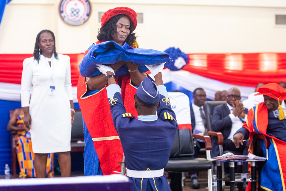 Acting Registrar receiving the gown