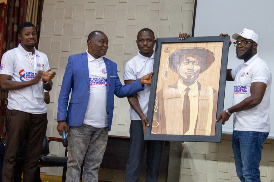 Prof. Benjamin Ghansah (right) receiving a personalised portrait from the IMCfPS Planning Committee in recognition of his contribution