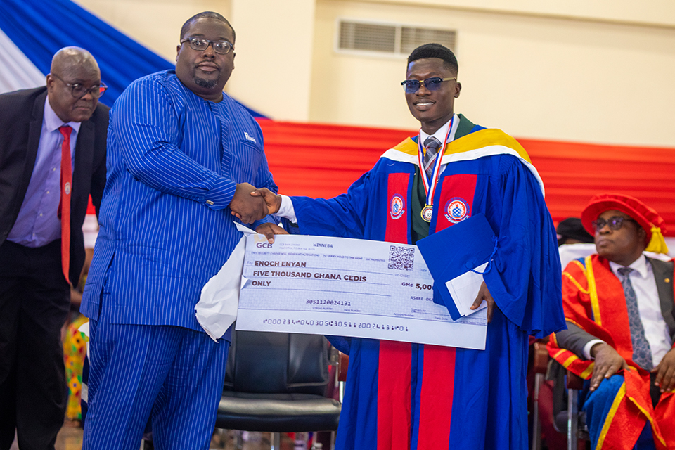 Enoch Enyan receiving a dummy cheque worth ₵5,000.00, one of the prestigious prizes awarded for being the Overall Best Student