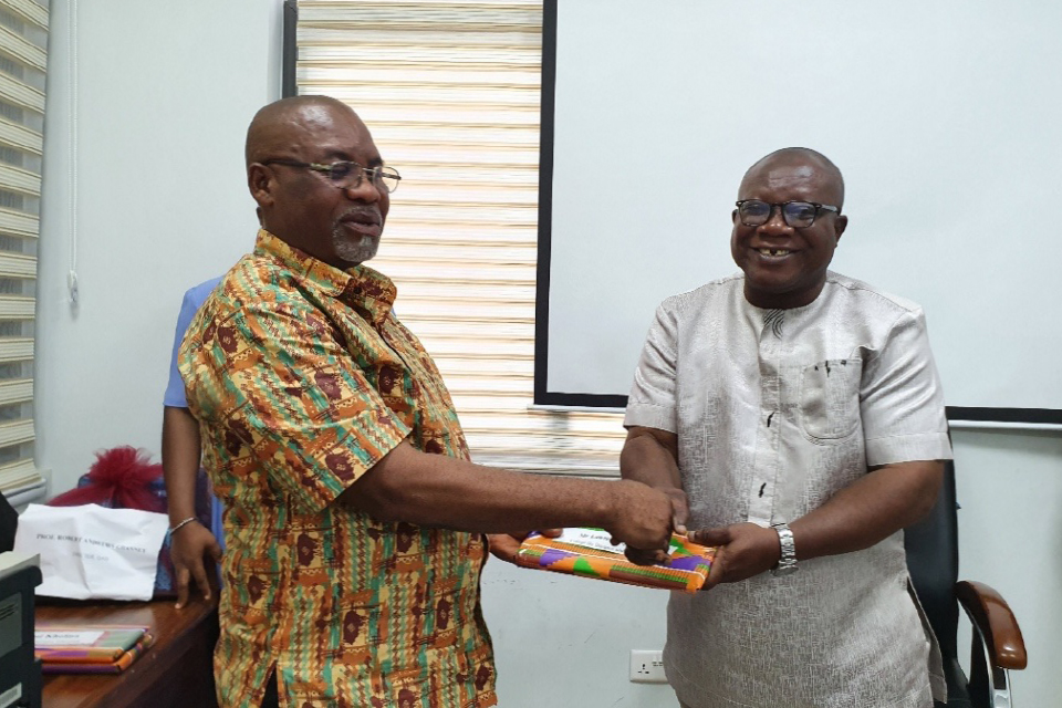 Prof. Ghanney presenting a token of appreciation to Mr. Lawrence Quarshie, Head of Quality Assurance Unit, CODeL